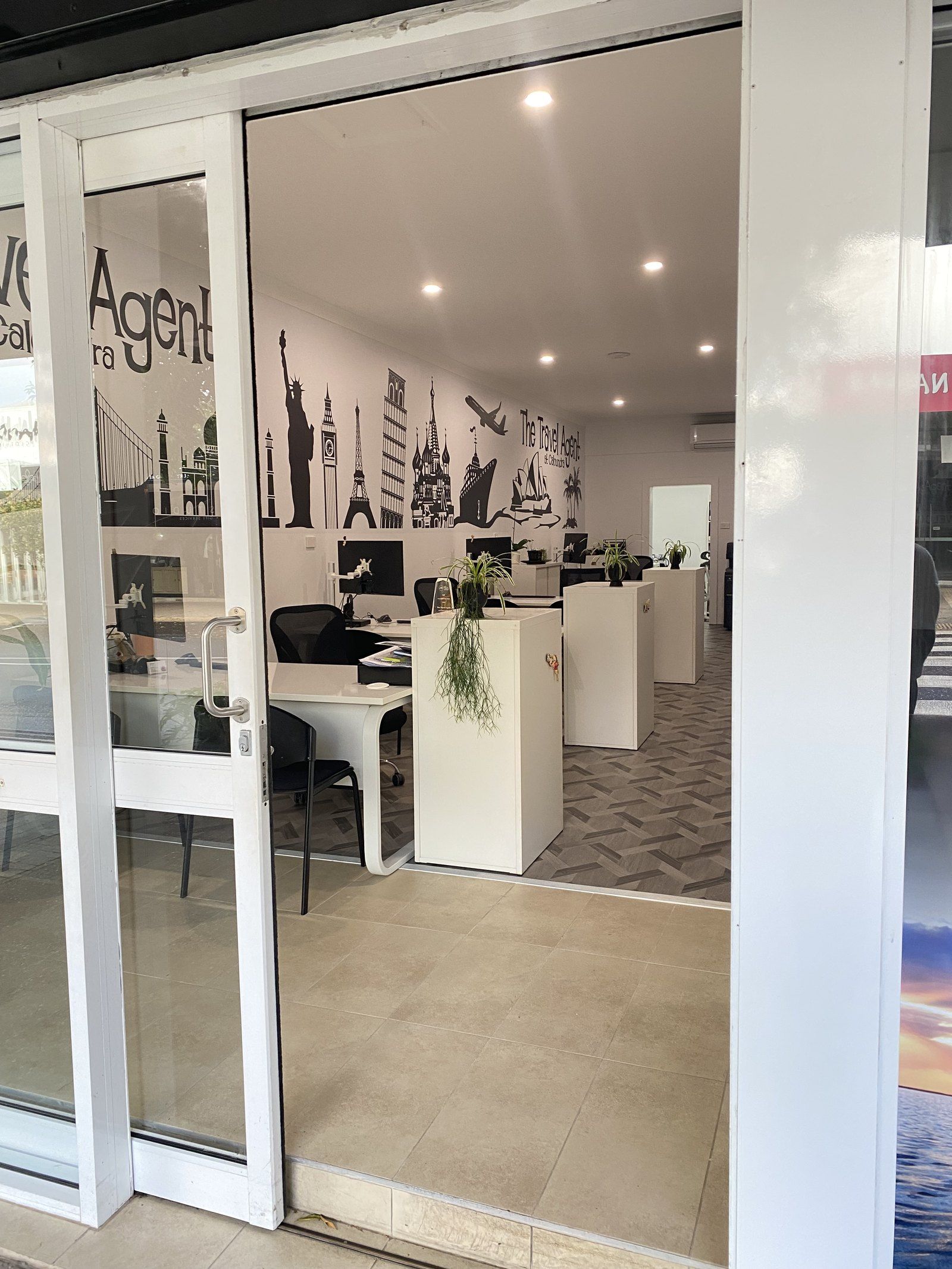 Inside the shop: consultants' desks in front of a black-and-white mural of world landmarks